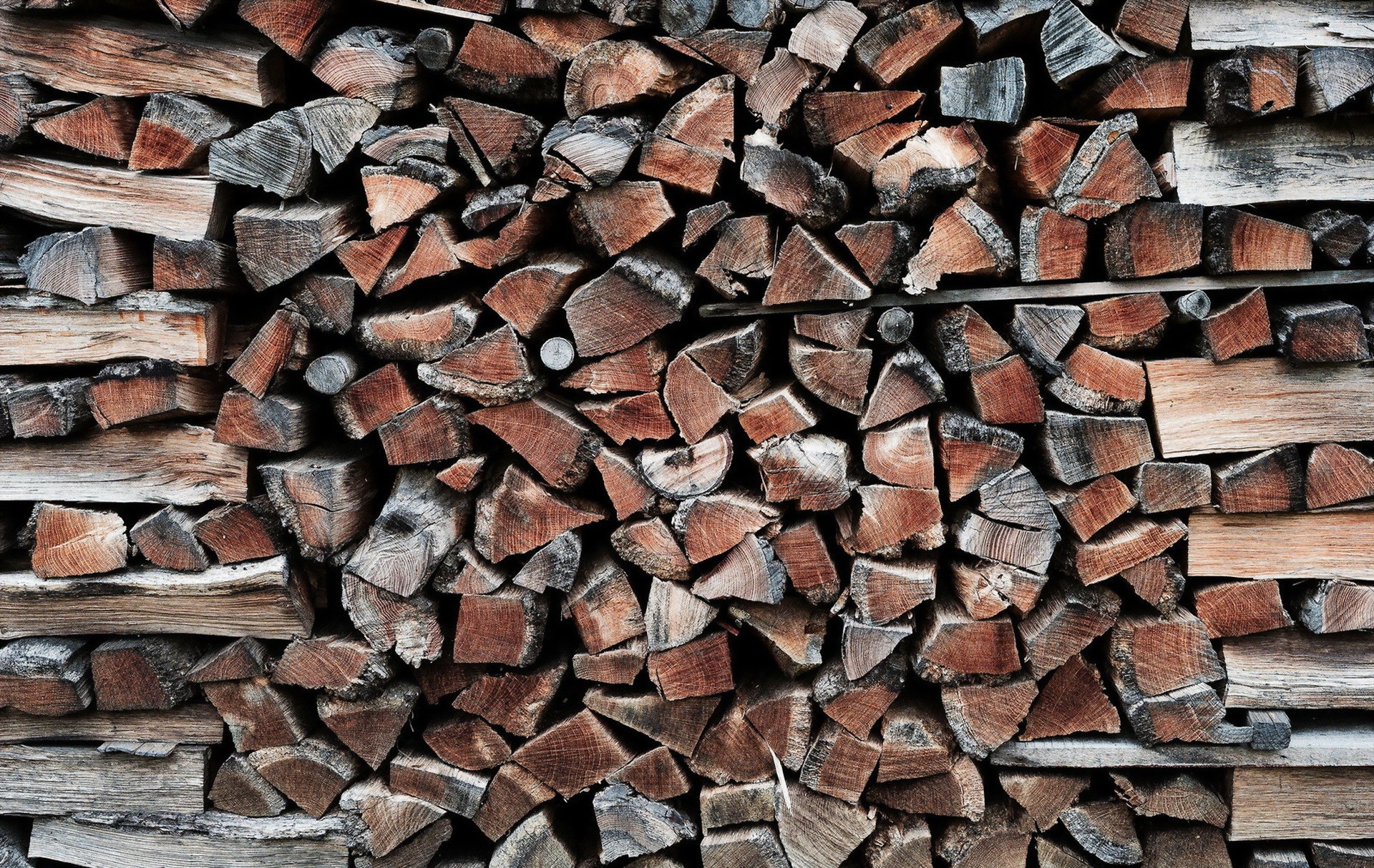 HD desktop wallpaper featuring a stack of chopped wood logs with a textured appearance.