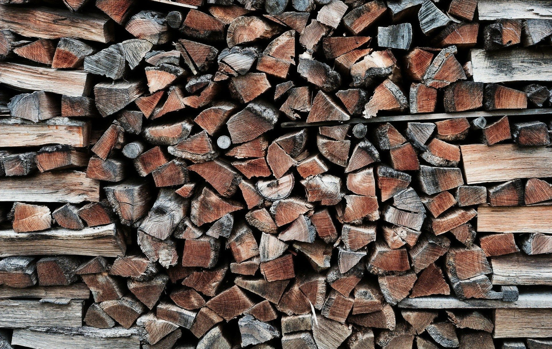 HD desktop wallpaper featuring a stack of chopped wood logs with a textured appearance.