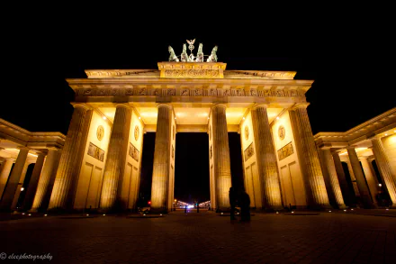 A stunning nighttime view of the Brandenburg Gate in Berlin, illuminated with warm lights, showcasing its grand architecture against the dark sky.