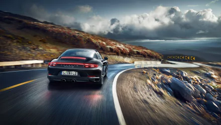 Black car Porsche 911 Targa rear view on a winding coastal road under stormy skies — Porsche 911 vehicle, 2K Quad HD PC desktop wallpaper.