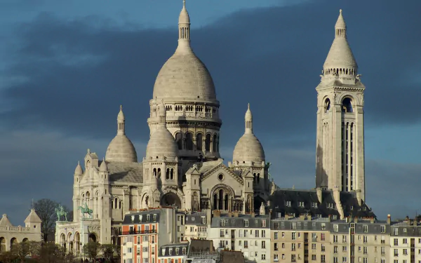 A stunning view of the Sacré-Cœur Basilica in Paris, showcasing its distinctive domes against a dramatic sky, ideal for enhancing any desktop background.