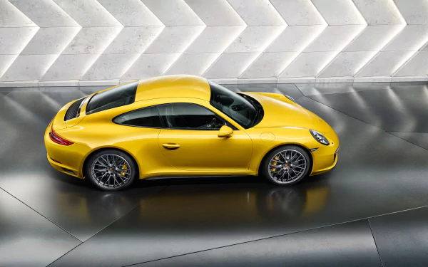 Yellow Porsche 911 Carrera 4S side profile on a reflective floor with geometric white wall backdrop — 2K Quad HD PC desktop wallpaper/background.