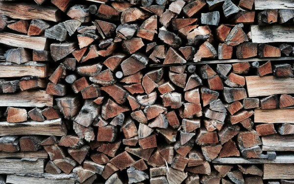 HD desktop wallpaper featuring a stack of chopped wood logs with a textured appearance.