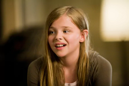 A close-up of Chloë Grace Moretz as Rachel Hansen, showcasing her expressive smile. Featured in a scene from the movie 500 Days of Summer, this vibrant 4K Ultra HD background adds warmth.