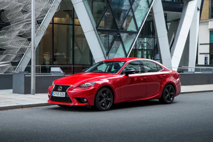 Red Lexus IS sedan parked by a modern glass building — crisp vehicle photo styled as a 2K Quad HD PC desktop wallpaper and background.