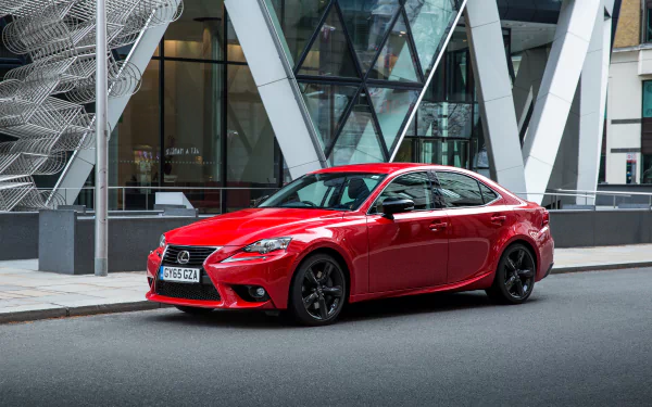 Red Lexus IS sedan parked by a modern glass building — crisp vehicle photo styled as a 2K Quad HD PC desktop wallpaper and background.