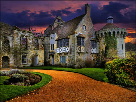 Close-up view of the historic Scotney Castle ruins in England at twilight, showcasing medieval stone walls and a winding path in this HD desktop wallpaper.