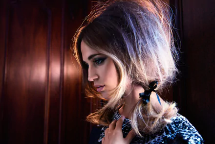 Alicia Vikander, a Swedish actress with brown eyes and brunette hair, is portrayed in a stylish HD wallpaper, highlighting her elegant profile against a dark background.