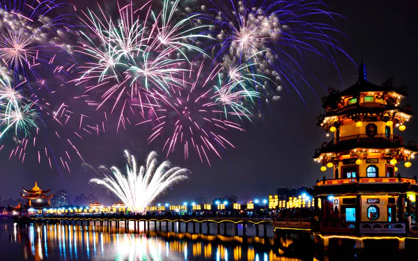 Vibrant fireworks light up the night sky over a traditional Taiwanese building, reflecting beautifully on the calm water in this HD desktop wallpaper.