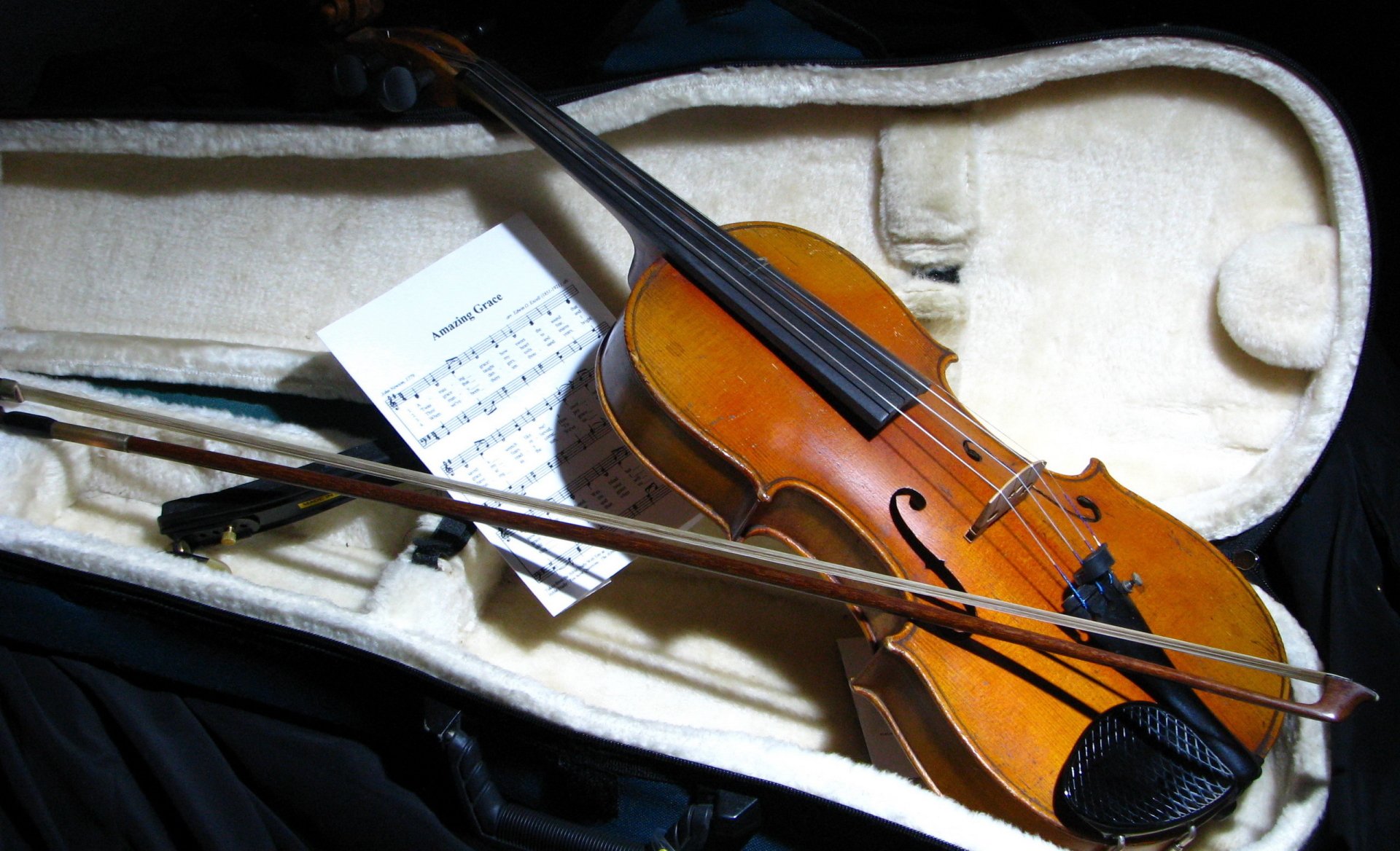 HD desktop wallpaper featuring a violin resting in its open case with sheet music, capturing the essence of music and classical artistry.