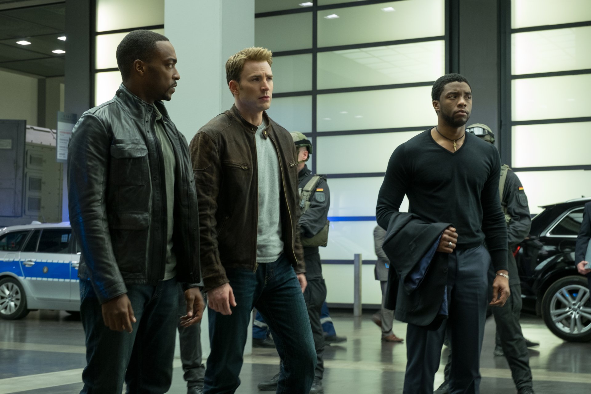A dramatic scene from Captain America: Civil War featuring Chadwick Boseman's Black Panther, Chris Evans as Captain America, and Anthony Mackie's Falcon in a tense standoff.