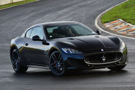 Black Maserati GranTurismo MC Sportline supercar captured on a racetrack, showcasing sleek design and powerful presence in stunning 4K Ultra HD quality.