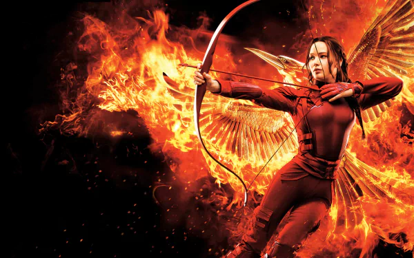 Katniss Everdeen, portrayed by Jennifer Lawrence, stands confidently with a bow amidst flames and phoenix wings in a dramatic scene from The Hunger Games: Mockingjay - Part 2.