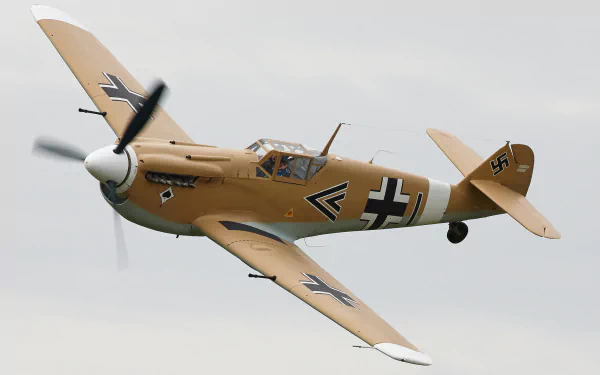 A Messerschmitt Bf 109 military warplane flying against a cloudy sky, showcasing its distinct design and coloration. High-definition desktop wallpaper and background.