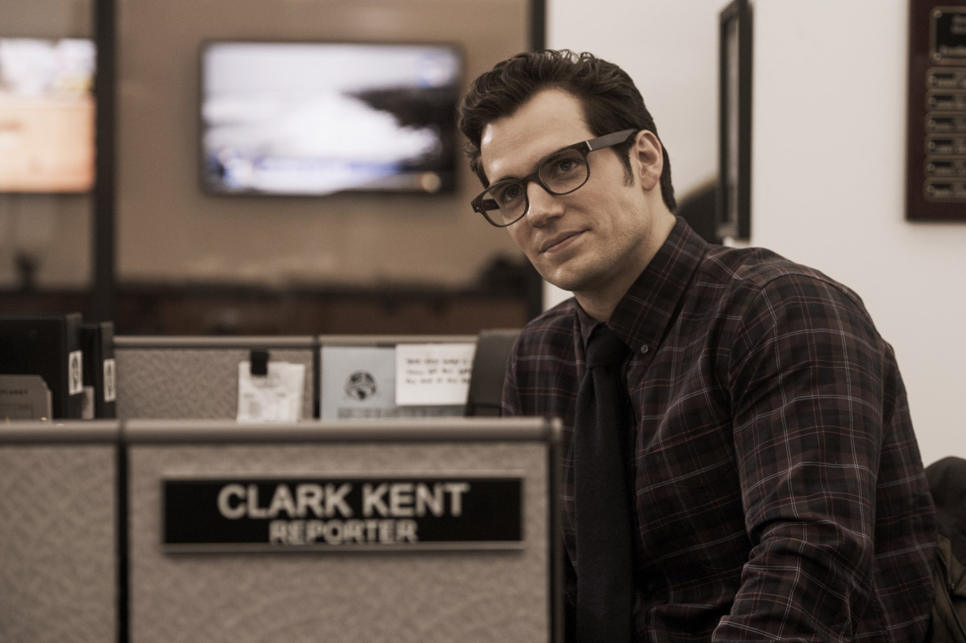 Clark Kent, portrayed by Henry Cavill, sits at his reporter desk in a scene from Batman V Superman: Dawn Of Justice. This 4K Ultra HD wallpaper captures his subtle heroism.