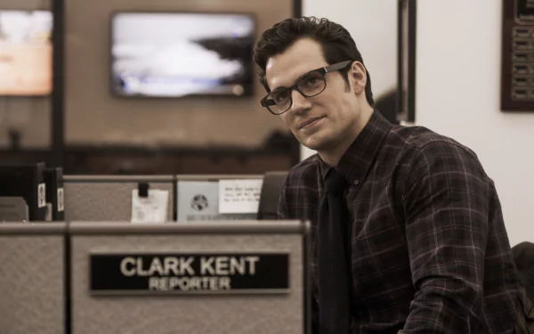 Clark Kent, portrayed by Henry Cavill, sits at his reporter desk in a scene from Batman V Superman: Dawn Of Justice. This 4K Ultra HD wallpaper captures his subtle heroism.