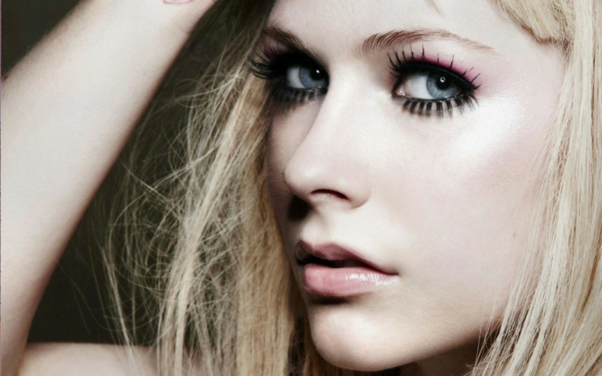 HD PC desktop wallpaper — close-up portrait of a Canadian singer's face: striking blue eyes, blonde hair and dramatic makeup, evoking a moody, music-inspired aesthetic.