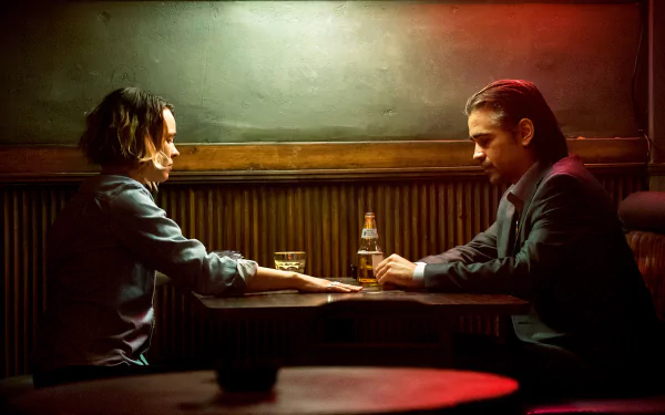 Rachel McAdams and Colin Farrell share a tense moment in a dimly lit bar setting from the TV show True Detective, capturing a gripping scene of drama and intrigue.