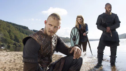 HD wallpaper featuring characters from the TV show Vikings (2013) includes Ragnar Lothbrok (Travis Fimmel), Lagertha (Katheryn Winnick), and Bjorn Lothbrok (Alexander Ludwig).