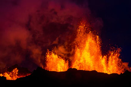 A dramatic 4K Ultra HD night view of Bárðarbunga volcano erupting in Iceland, with glowing lava and thick smoke contrasting against the dark sky.