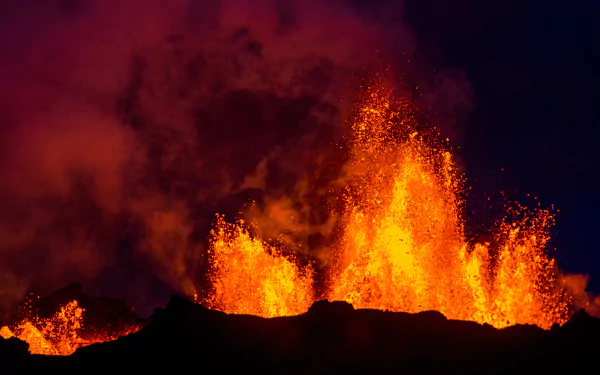 A dramatic 4K Ultra HD night view of Bárðarbunga volcano erupting in Iceland, with glowing lava and thick smoke contrasting against the dark sky.