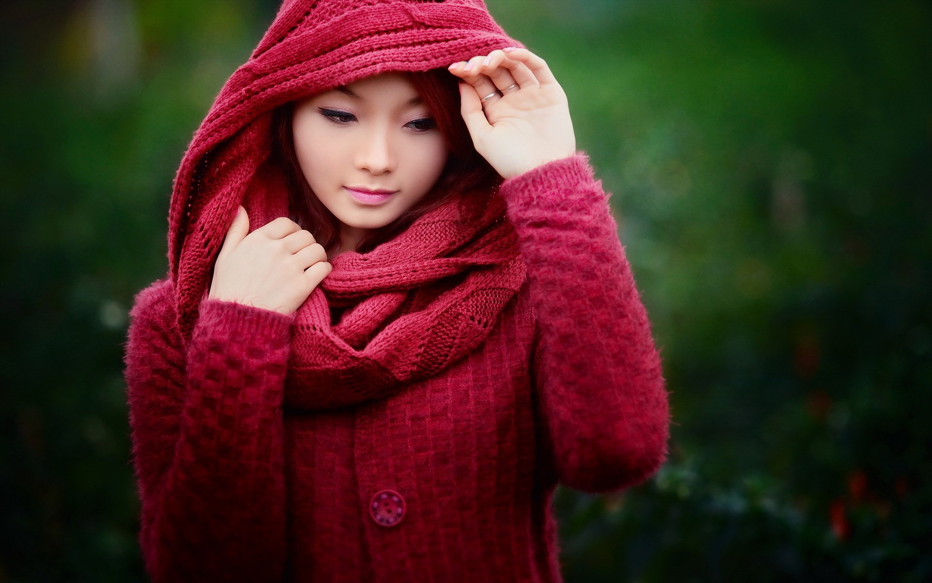 HD desktop wallpaper featuring an Asian model in a red scarf and sweater, set against a blurred green background.