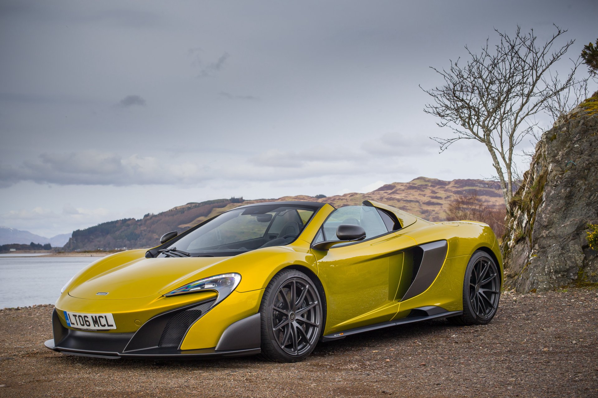 Yellow McLaren 675LT supercar on a coastal road with hills and sea in the background — 4K Ultra HD PC desktop wallpaper.
