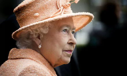 HD PC desktop wallpaper showing a close-up profile of Queen Elizabeth II wearing a peach hat and matching outfit, with a soft focused background.