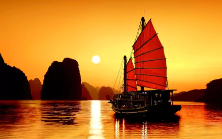 A vibrant sunset over Ha Long Bay, Vietnam, features a traditional sailboat with striking red sails gliding across the calm waters, framed by silhouetted karst formations.
