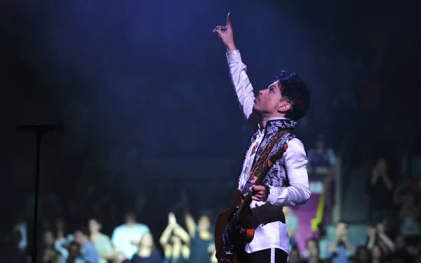 Prince, the American singer, performs on guitar during a concert, captured in high definition as a dynamic PC desktop wallpaper background.
