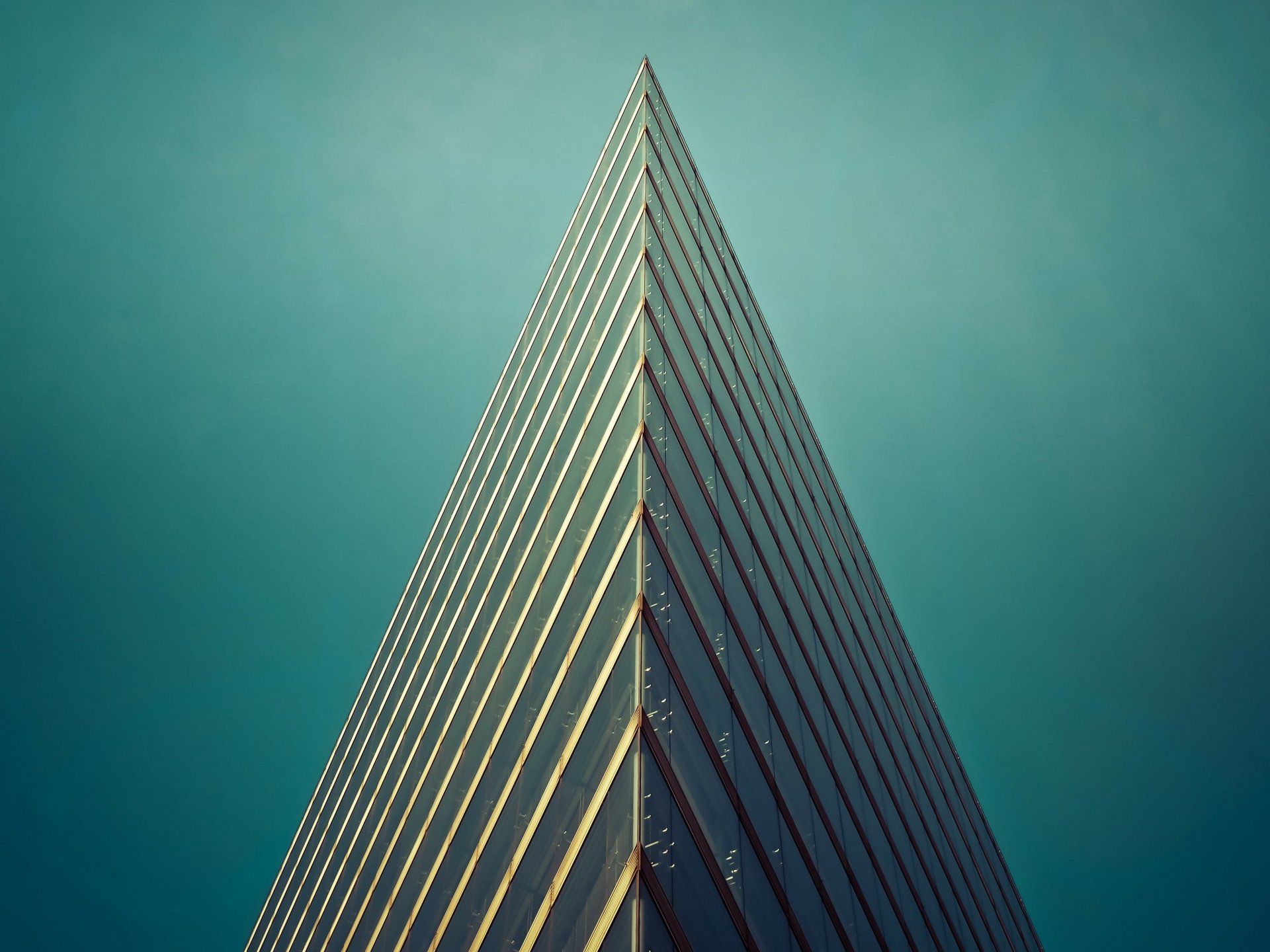 Minimalist man-made building with sharp triangular edges against a clear sky, captured in 4K Ultra HD for a striking desktop wallpaper background.