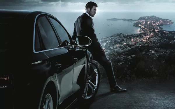 HD PC desktop wallpaper featuring a scene from the movie The Transporter Refueled, showing a man leaning against a black car overlooking a coastal city at dusk.