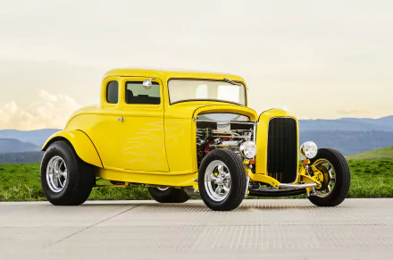 4K Ultra HD PC desktop wallpaper: yellow vintage hot rod — classic old car parked on pavement with grassy hills and distant mountains.