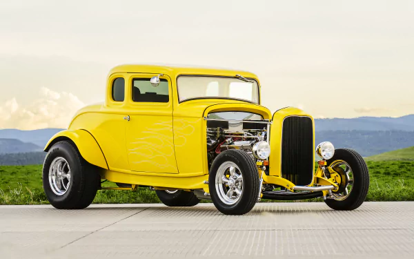 4K Ultra HD PC desktop wallpaper: yellow vintage hot rod — classic old car parked on pavement with grassy hills and distant mountains.