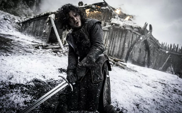 Jon Snow, portrayed by Kit Harington, stands wielding a sword in a snowy landscape, evoking the dramatic intensity of the TV show Game of Thrones in this HD wallpaper.