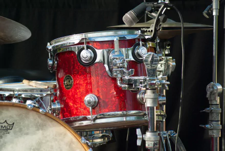 Close-up of a vibrant red drum set with cymbals and a microphone, capturing the essence of music and performance. A striking HD desktop wallpaper for music enthusiasts.