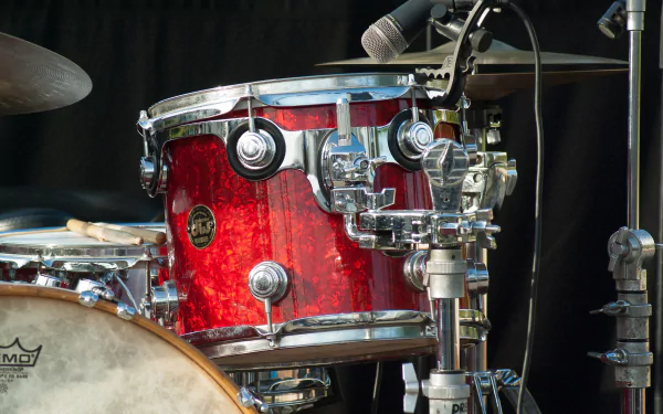 Close-up of a vibrant red drum set with cymbals and a microphone, capturing the essence of music and performance. A striking HD desktop wallpaper for music enthusiasts.