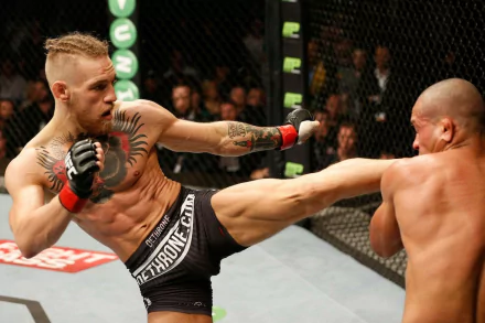 A dynamic UFC action shot featuring Conor McGregor mid-fight, delivering a powerful kick to his opponent, capturing the intensity of sports competition in high definition.