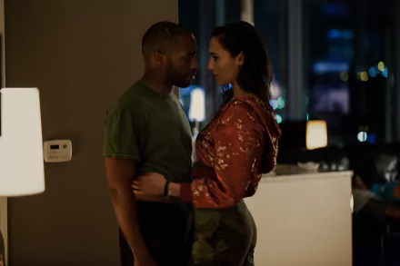 Gal Gadot and Chiwetel Ejiofor share an intimate moment in a scene from the movie Triple 9. The image captures their chemistry and the film's dramatic storytelling in rich detail.