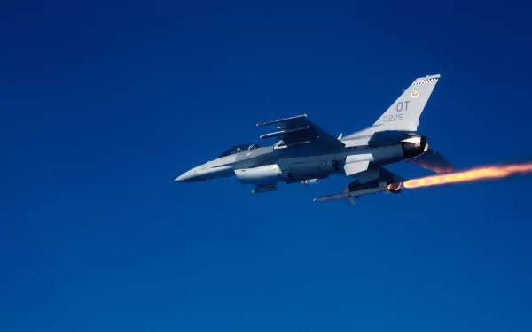 General Dynamics F-16 Fighting Falcon aircraft in flight, launching a missile against a clear blue sky, captured in high-definition for a PC desktop wallpaper.