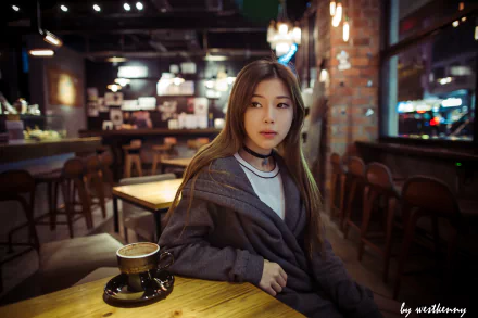 A brunette Asian woman with brown eyes sits thoughtfully at a pub table at night, with a cup of coffee in front of her, captured in 4K Ultra HD desktop wallpaper quality.