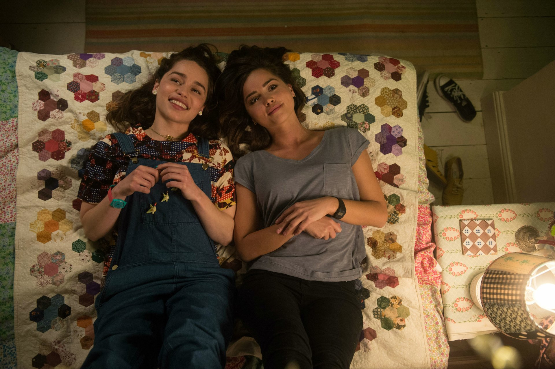 Jenna Coleman and Emilia Clarke lie on a colorful quilt, sharing a relaxed moment in a scene from the movie Me Before You, presented in 4K Ultra HD.