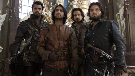 HD PC desktop wallpaper of four leather-clad musketeers from the TV show The Musketeers, standing with swords in an ornate hall, faces set with resolve.