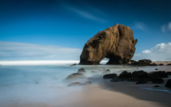 4K Ultra HD desktop wallpaper of Santa Cruz beach featuring a natural rock formation by the sea under a vibrant blue sky, showcasing coastal landscape and nature.