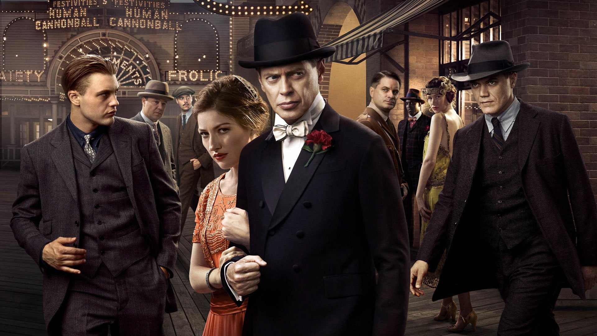 HD desktop wallpaper featuring characters from the TV show Boardwalk Empire dressed in 1920s attire on a boardwalk at night.