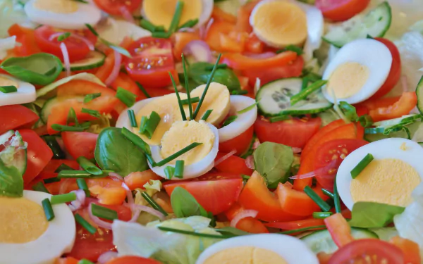 Close-up of a fresh lunch salad with sliced cucumbers, tomatoes, and boiled eggs, captured in vivid 4K Ultra HD quality for a PC desktop wallpaper.