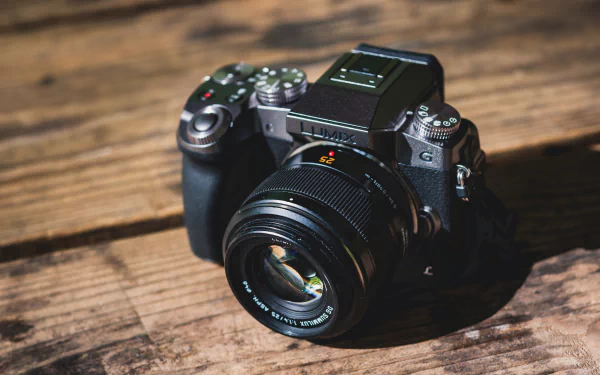 HD desktop wallpaper featuring a Lumix man-made camera placed on a wooden surface, showcasing detailed lens and body design in natural light.