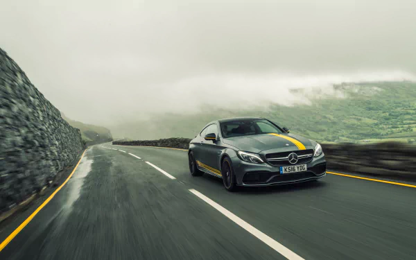 Silver Mercedes-Benz C-Class car driving on a winding mountain road under cloudy skies, captured in 4K Ultra HD for a PC desktop wallpaper.