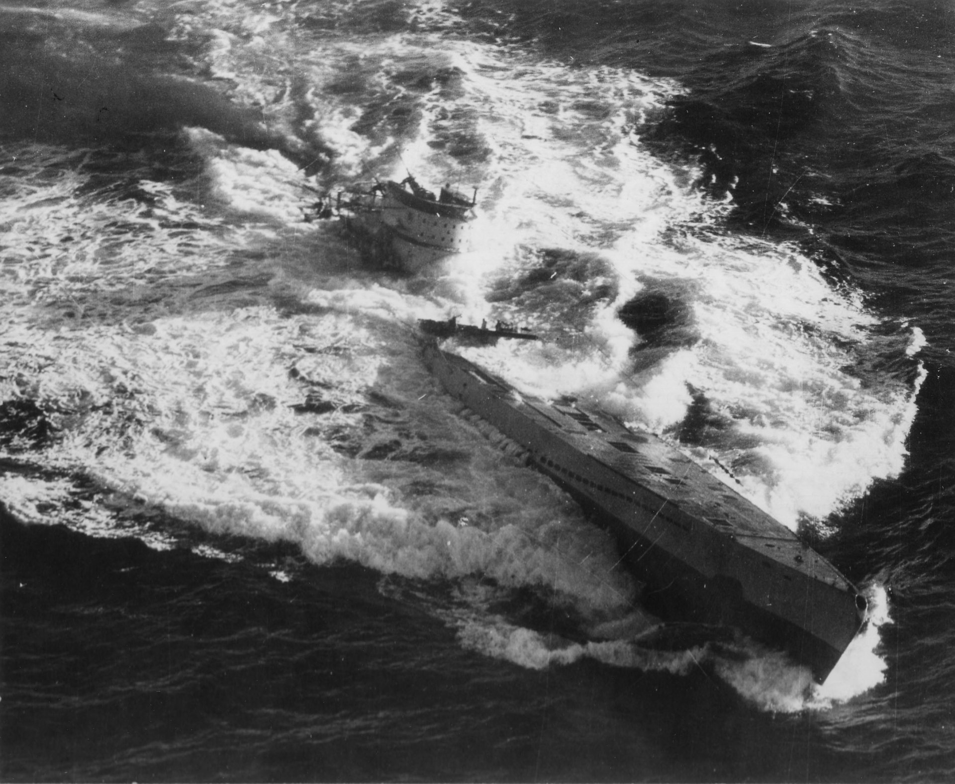 Black and white HD desktop wallpaper of a World War II U-boat submarine cutting through turbulent ocean waters, highlighting its military power and stealth.