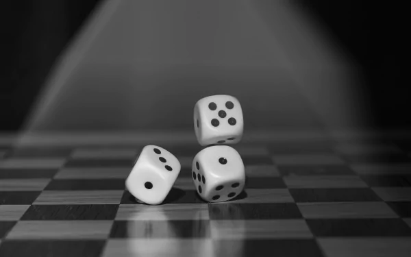 Black and white 4K Ultra HD wallpaper featuring three dice on a checkered surface with focused lighting highlighting their details.